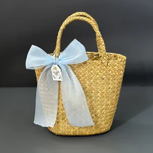 Handmade woven straw gift basket with blue bow, pastoral style wedding party storage container.