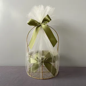 Gold metal wire gift basket with white tulle and green satin bow for wedding party favors.