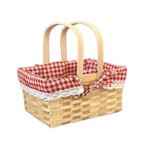 Hand-woven picnic basket with red checkered fabric lining and double wooden handles.