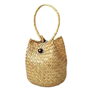 Handmade seagrass woven basket bag with round handle and wooden toggle closure