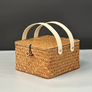 Détail de boite cadeau en rotin tissé, panier de rangement portable avec poignées blanches.