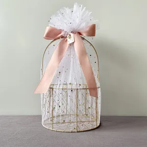 Golden metal gift basket with white star tulle and pink ribbon for wedding party packaging.