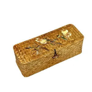 Handwoven seagrass storage box with floral embroidery lid and a wooden button closure