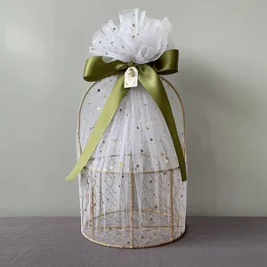 Golden metal gift basket with white star tulle and green ribbon for wedding party.