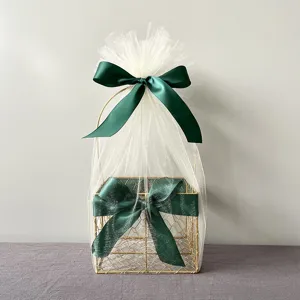 Golden metal gift basket with white tulle and dark green satin bow for wedding party favors and gifts