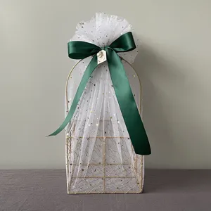 Gold wire gift basket with white star tulle and dark green bow for wedding and holiday presents.