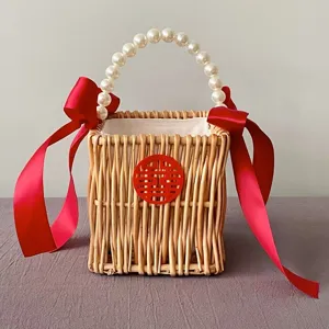 Handmade wicker gift basket with pearl handle and red ribbons for wedding favors