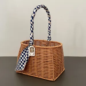 Handgeweven rotan mand cadeaubox met blauw patroon lint en geluksetiket voor bruiloften.