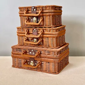 Set of three stacked vintage brown woven rattan suitcases with elegant gold latches