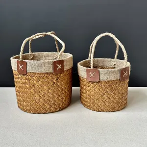 Handmade seagrass woven storage basket with burlap rim and handles for home organization.