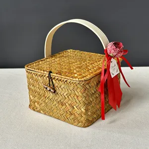 Boîte-cadeau en rotin tressé avec décoration en ruban rouge et détail de poignée