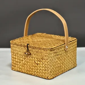 Gros plan détaillé d'une boîte cadeau carrée en rotin tressé avec sa poignée en cuir