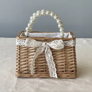 Detailed view of handmade wicker basket with pearl handle and white lace bow