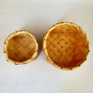 Top-down detail of the cross-woven texture on two handmade wooden storage baskets