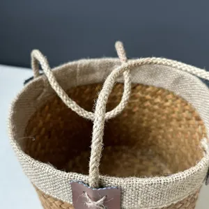 Detailed view of handmade natural seagrass woven storage basket with durable rope handles.