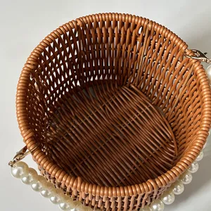 Round woven rattan basket handbag with pearl handle for wedding gift packaging and daily style.