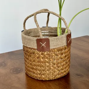 Handmade seagrass woven storage basket with jute handles and leather patch detail for plant home.
