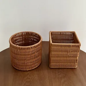 Close-up detail of woven plastic storage baskets, round and square styles on wood table.