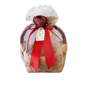 Handgemaakte geweven rattan geschenkmand met rode lint en gaas voor bruiloft en opslag.