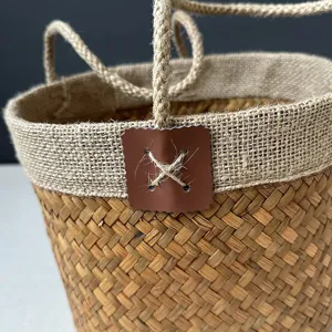Handmade seagrass woven storage basket with hemp rope handles for home organization.