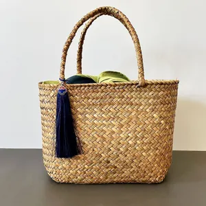 Handmade seagrass woven tote basket with decorative blue tassel and inner lining