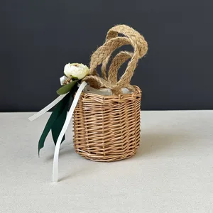 Detailed close-up of a handmade woven straw basket with jute rope handles and floral decor.