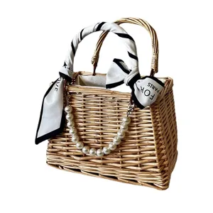 Handwoven natural rattan gift basket with decorative pearl chain and elegant silk scarf handle