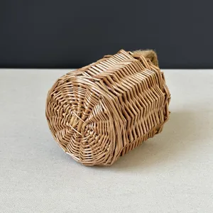 Woven wicker cylinder basket detail shot, mini natural straw bag with hemp rope handle.