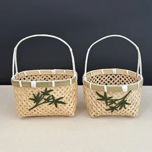 Gros plan sur de petits paniers en bambou tressé main avec broderie de feuilles vertes