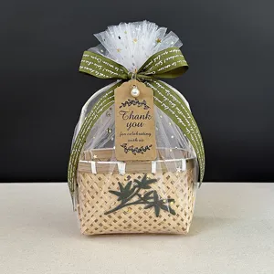 Détail d'un mini panier cadeau en bambou tissé avec sac en tulle et carte de merci