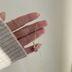 Elegante collana dorata con un ciondolo a forma di renna rotante e piccoli zirconi
