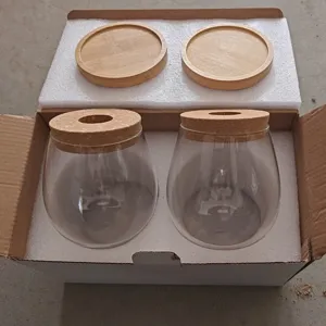Juego de dos jarrones de vidrio transparente con tapas de corcho y bases de madera