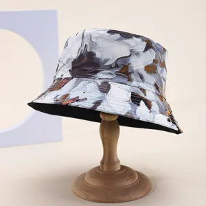 Detail view of a stylish reversible floral bucket hat shown on a wooden display stand