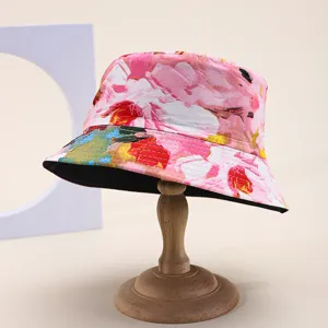 Floral print double-sided bucket hat for summer sun protection shown on a wooden stand.