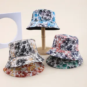 Collection of patterned bucket hats with colorful leaf prints on a beige background