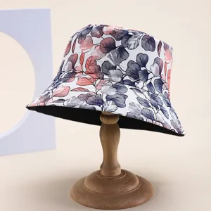 Reversible floral print bucket hat for summer sun protection shown on wooden stand