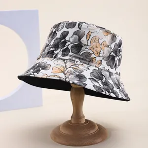 Detailed view of a reversible floral print bucket hat on a wooden display stand