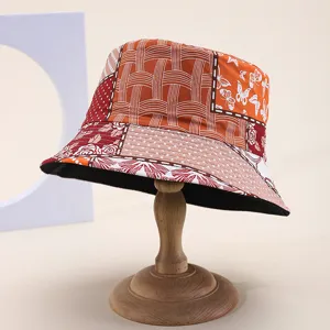 Patchwork-Eimerhut im Detail mit bunten Schmetterlings- und Webmustern, stylischer Sonnenschutz.