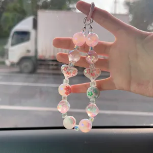 Dettaglio del ciondolo per cellulare in perline dipinte a mano con cuori OMG rosa