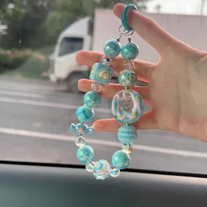 Ciondolo per telefono fatto a mano con perle colorate, ciambella blu e stile caramella