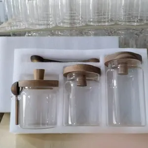 Gedetailleerd overzicht van heldere glazen voorraadpotten met houten deksels en lepels.