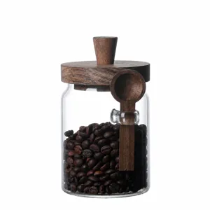 Clear glass storage jar with acacia wood lid and spoon, perfect for coffee beans and tea.