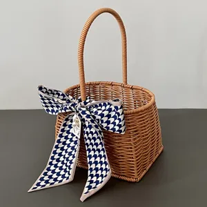 Handgemaakte geweven rattan cadeau mand met blauwe strik lint en parel hanger voor feest.