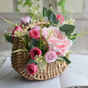Detailansicht eines handgefertigten Weidenkorbs mit künstlichen rosa Rosen