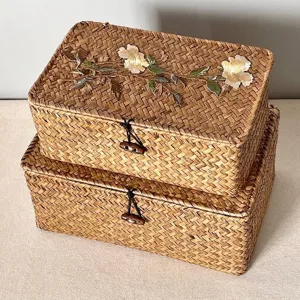 Detail shot of handwoven storage basket featuring elegant floral embroidery and toggle closure