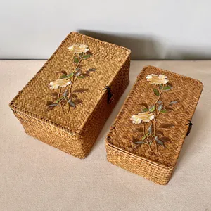 Top view of two handmade woven gift boxes with elegant floral embroidery details