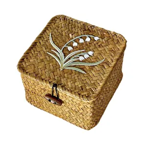 Hand-woven square straw gift box with lily of the valley embroidery and wooden toggle.