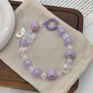 Detailed view of purple iridescent and clear beaded phone charm with butterfly bead.