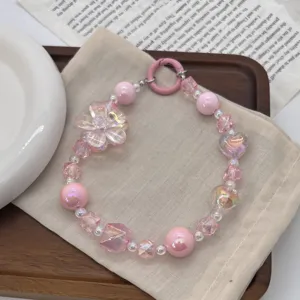 Detailed shot of a sweet pink beaded phone strap featuring flower and heart charms