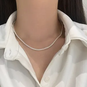 Detailed view of a minimalist sparkling silver star chain necklace on model neck